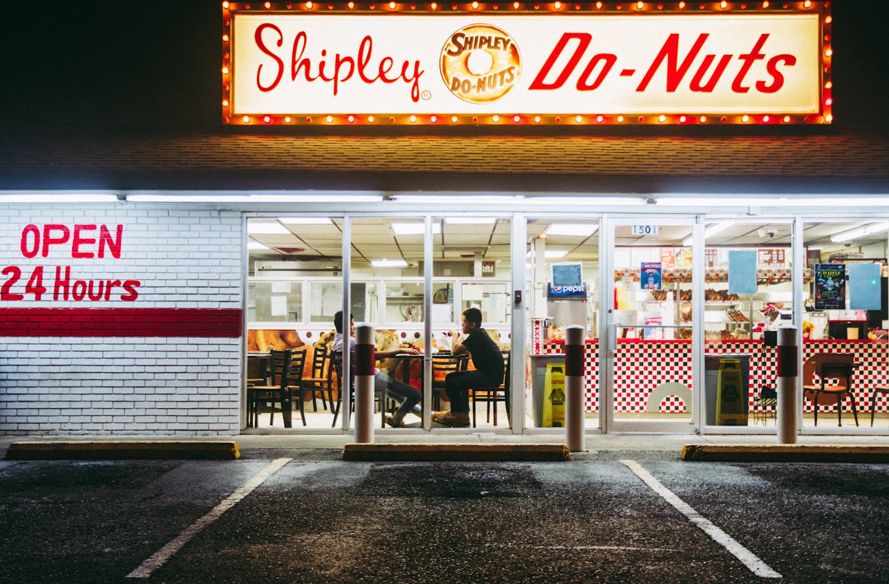 services-01 Brightly lit Shipley Do-Nuts shop in McAllen, TX, open 24/7. Nighttime urban scene.
