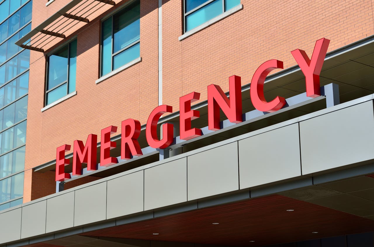 who-we-are Close-up of a modern hospital emergency room entrance with prominent red letters.